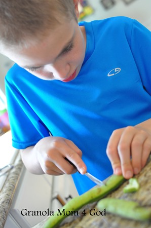 child cutting fava beans